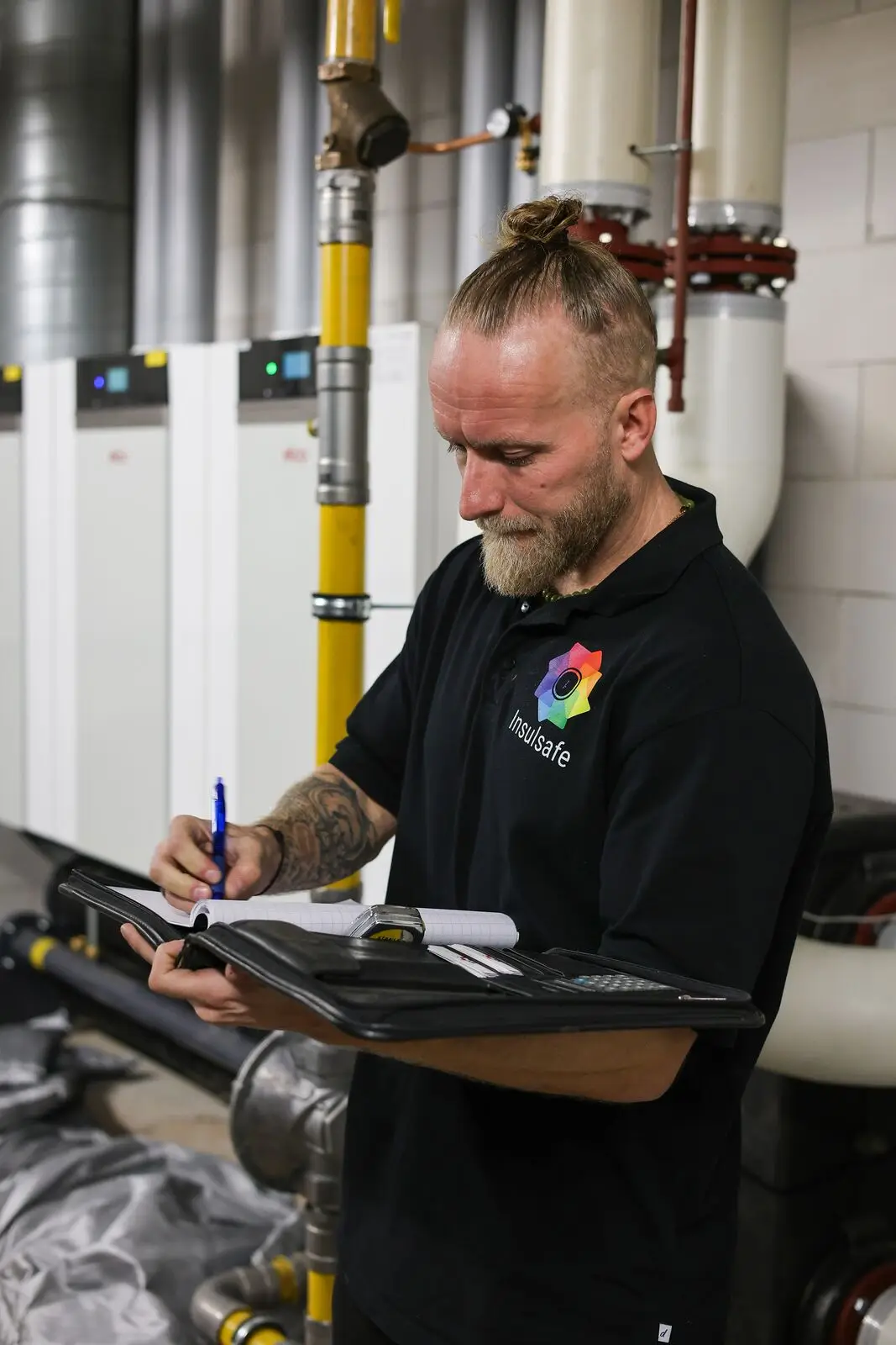 InsulSafe-monteur neemt maten op in een ketelhuis met cv-installatie