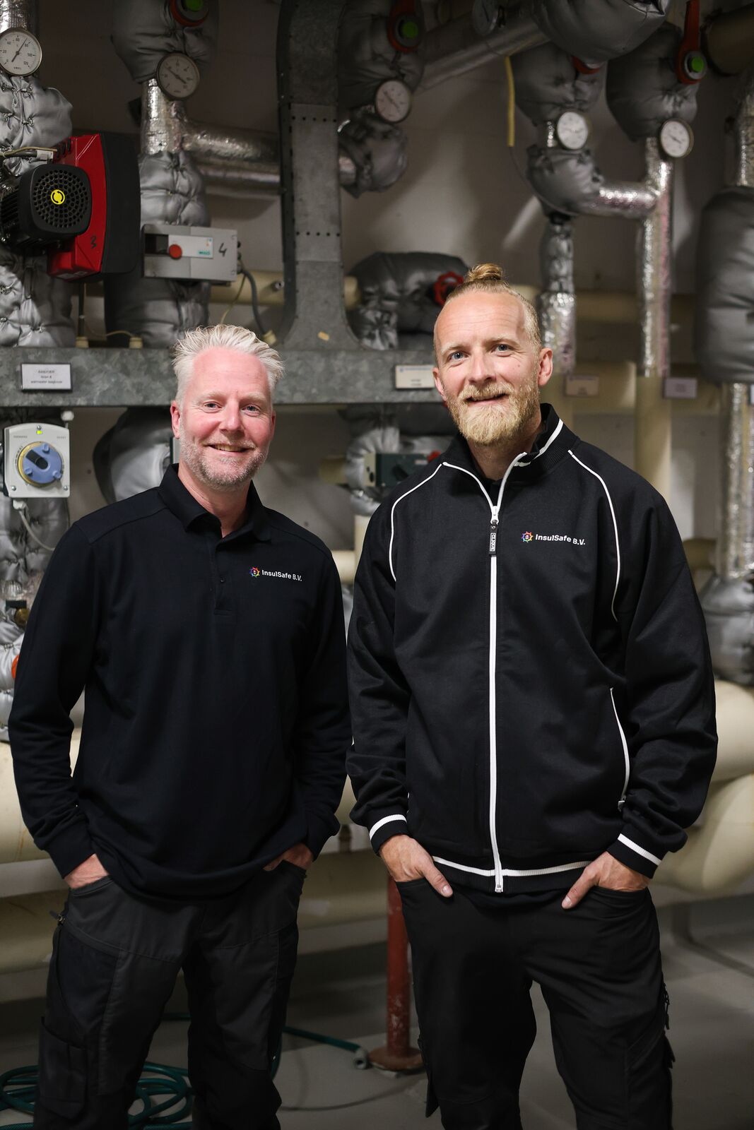 Twee InsulSafe-monteurs aan het werk in een technische ruimte